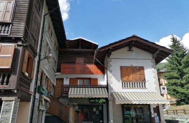 Edificio alpino con negozio e balconi in legno.