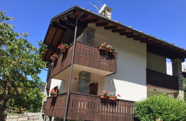 Alpine house with wooden balconies and flowers.