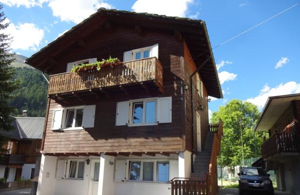 Wooden chalet with flowered balcony in the mountains.