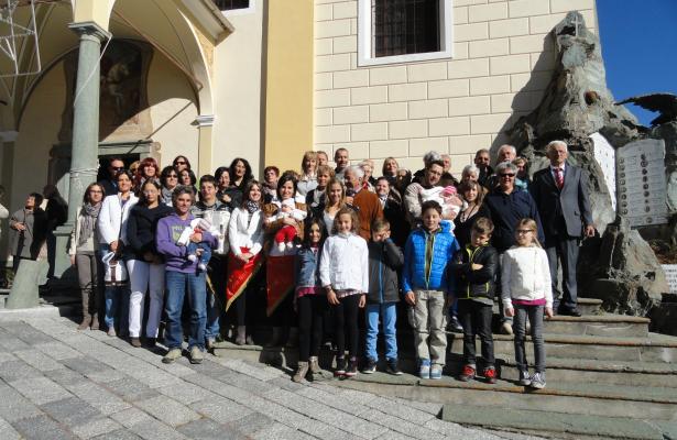 Gruppo di persone davanti a una chiesa, giornata soleggiata.